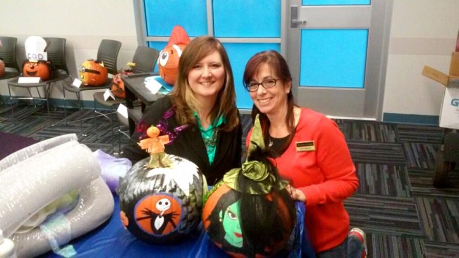 Two staff members showcase their decorated pumpkins during an event sponsored by COD Cares at College of DuPage.