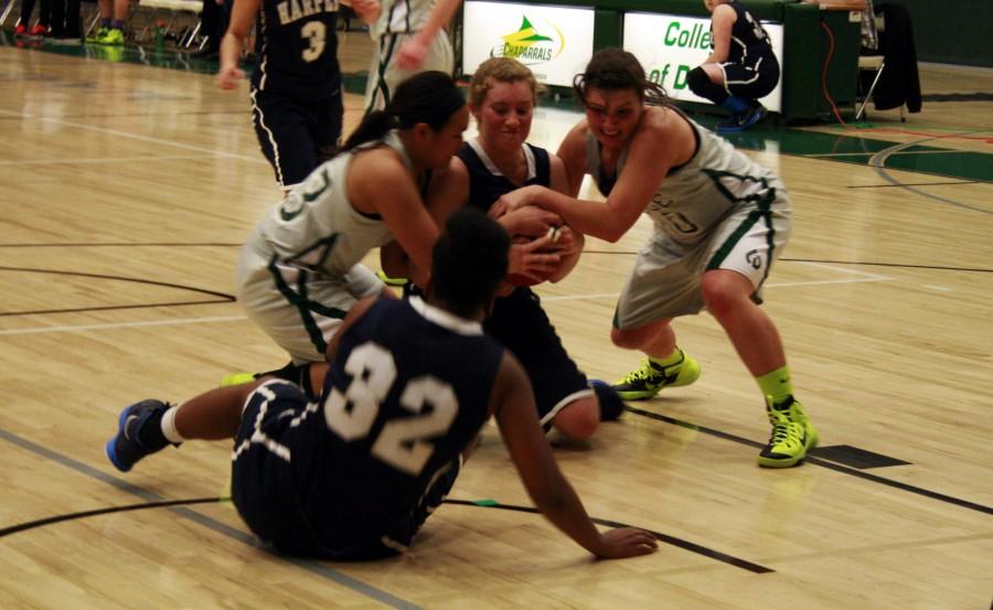 Lady Chaparral Basketball players battling to rip the ball out of a harper player at the College of DuPage home court on Jan. 17. The Lady Chaps are on a four game losing streak in the conference. 