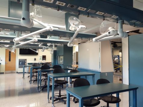 Forensics laboratory and classroom, with overhead lamps at each table and evidence storage in the back.
