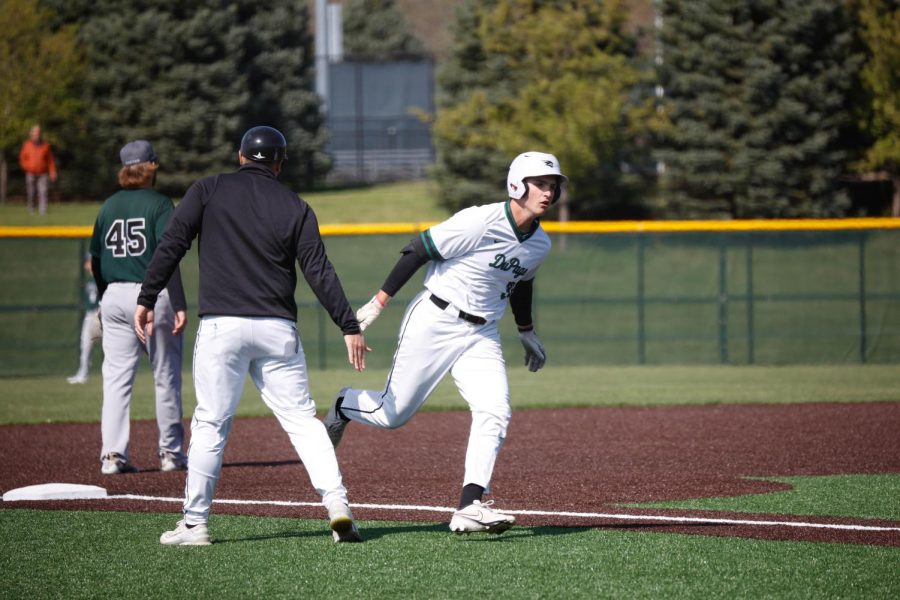 Sophomore outfielder Jason Cousineau high-fives head coach Bobby Wilson after hitting a home run. 