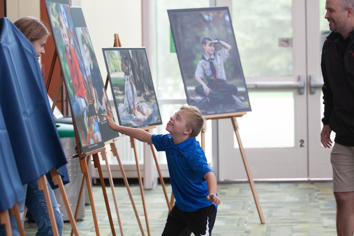 Colton runs up to see his portrait. His photo was taken by Rebecca Morrison.
