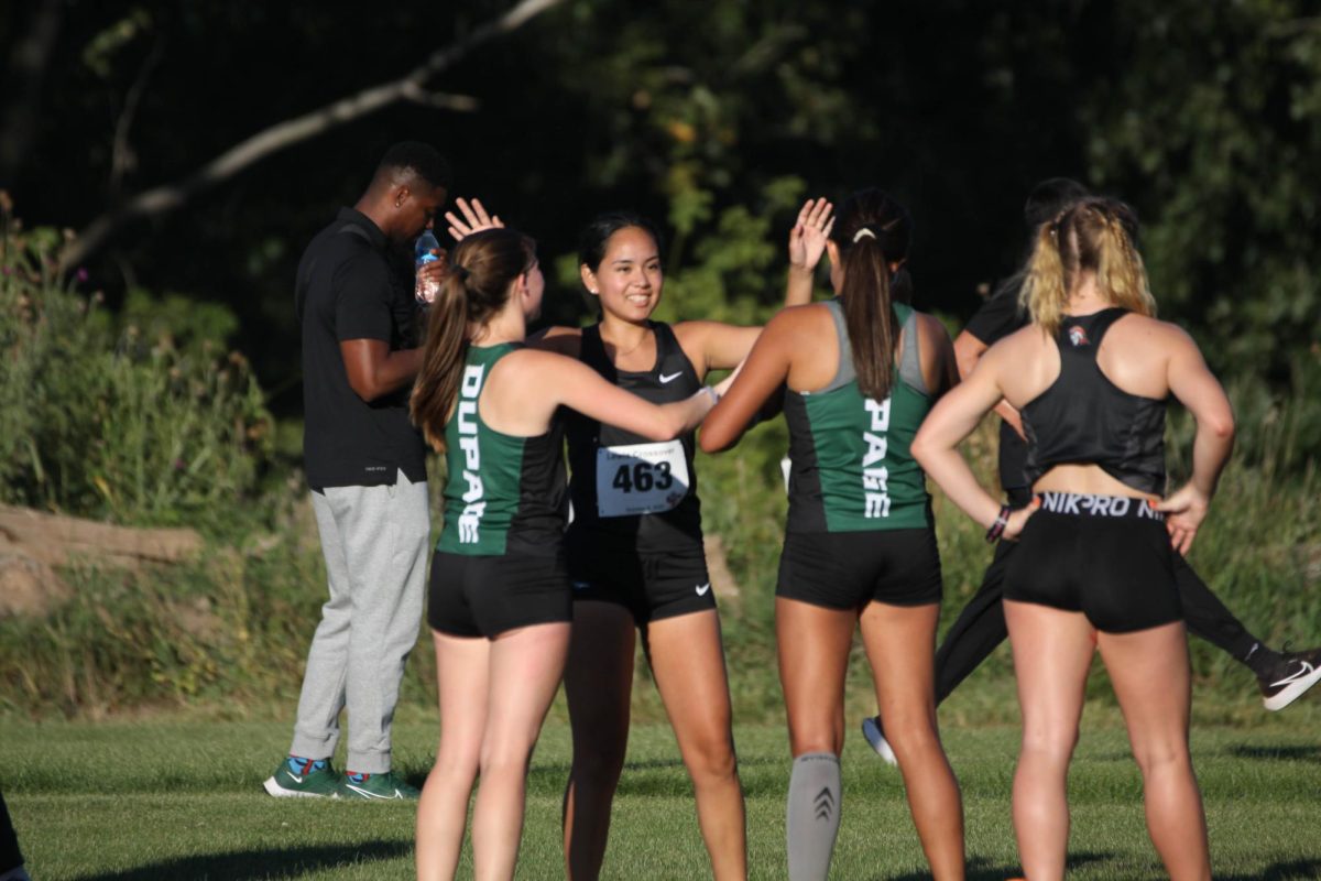 Members of the women’s cross country team high five before the race.
