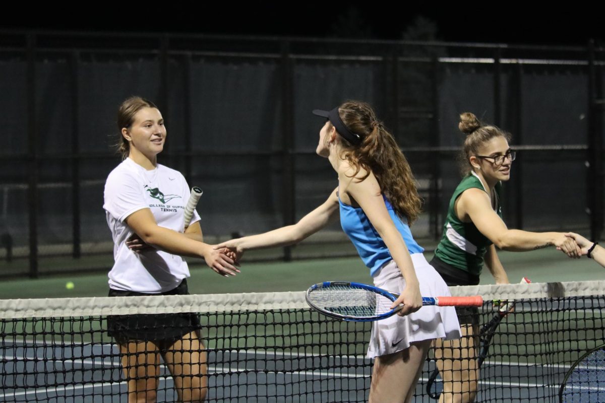 Freshman Natalia Klus and sophomore Adele Hutton shake hands with their opponents after the doubles match. 