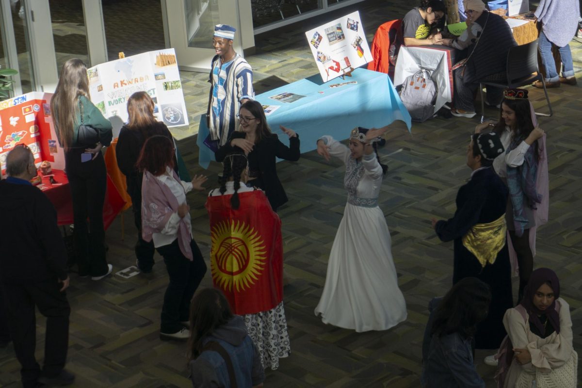 A group of students dance in the middle of the Atrium.