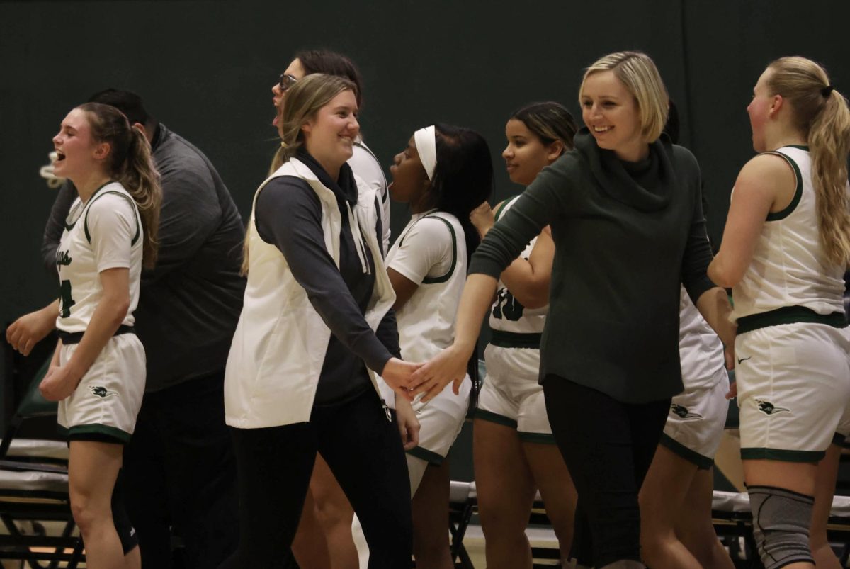 Assistant coach Jordan Heberg and head coach Abigail Talley high five after the team won against Triton.
