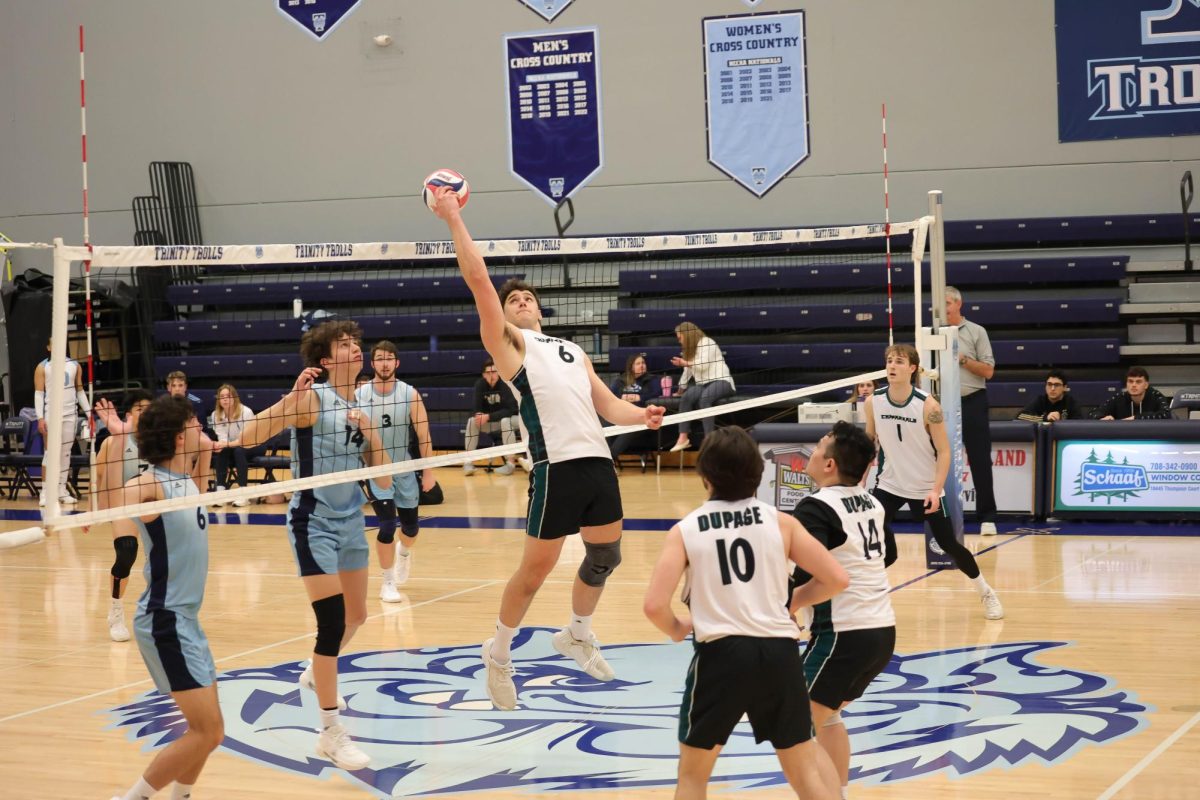 Freshman middle hitter Justus Barbel reaches behind to hit the ball past the defenders. 