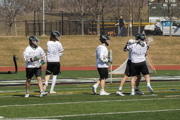 The COD mens lacrosse team celebrates after scoring a goal. 