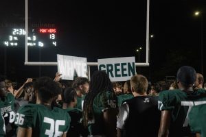 COD football fans hold "white" and "green" signs after the game. 