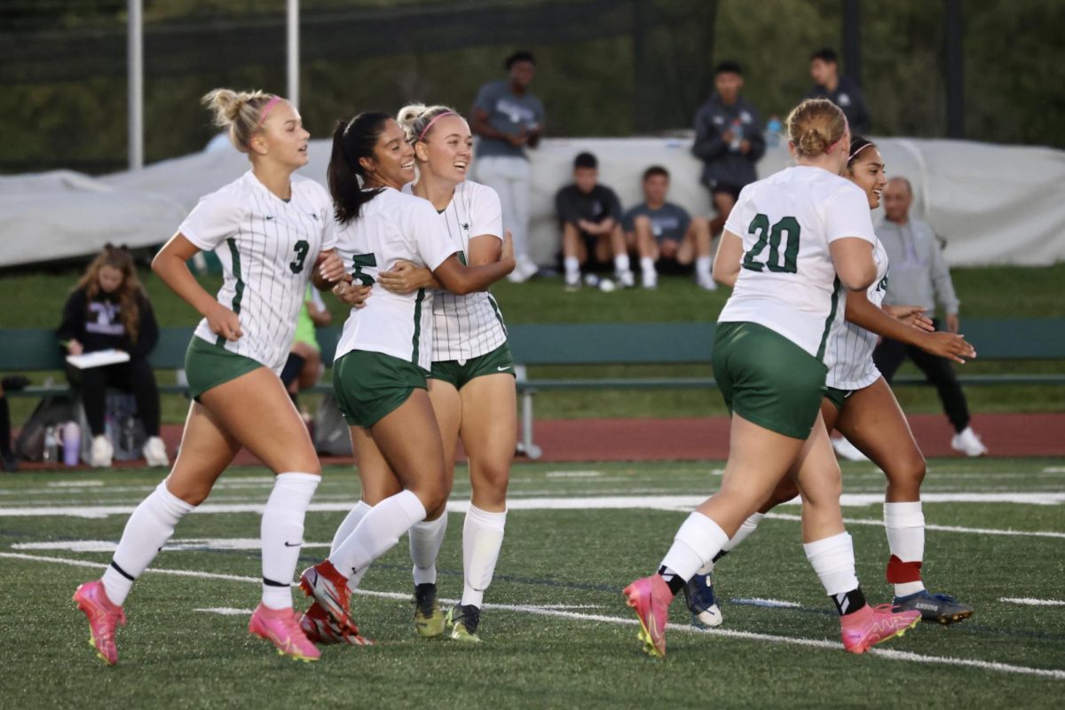 Freshman Mariel Lara hugs Joli Weigandt and celebrates with her teammates after scoring a goal.  