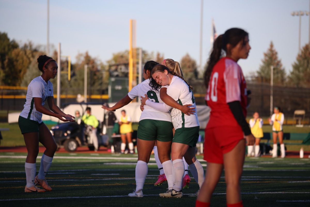 The COD women's soccer team celebrates after scoring a goal.