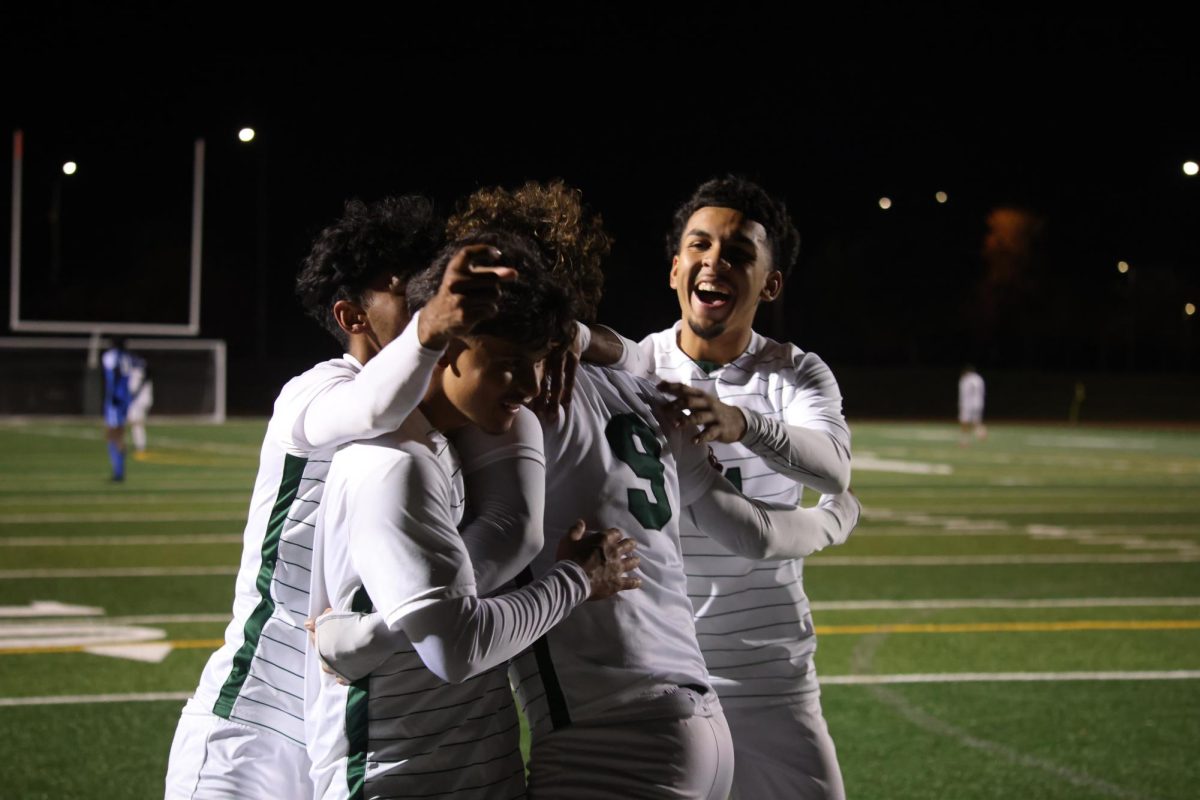 A group of Chaps players huddle around Anthony Juarez to celebrate his goal.