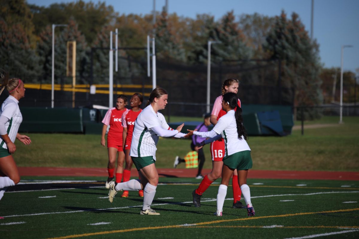 The COD women's soccer team celebrates after scoring a goal.