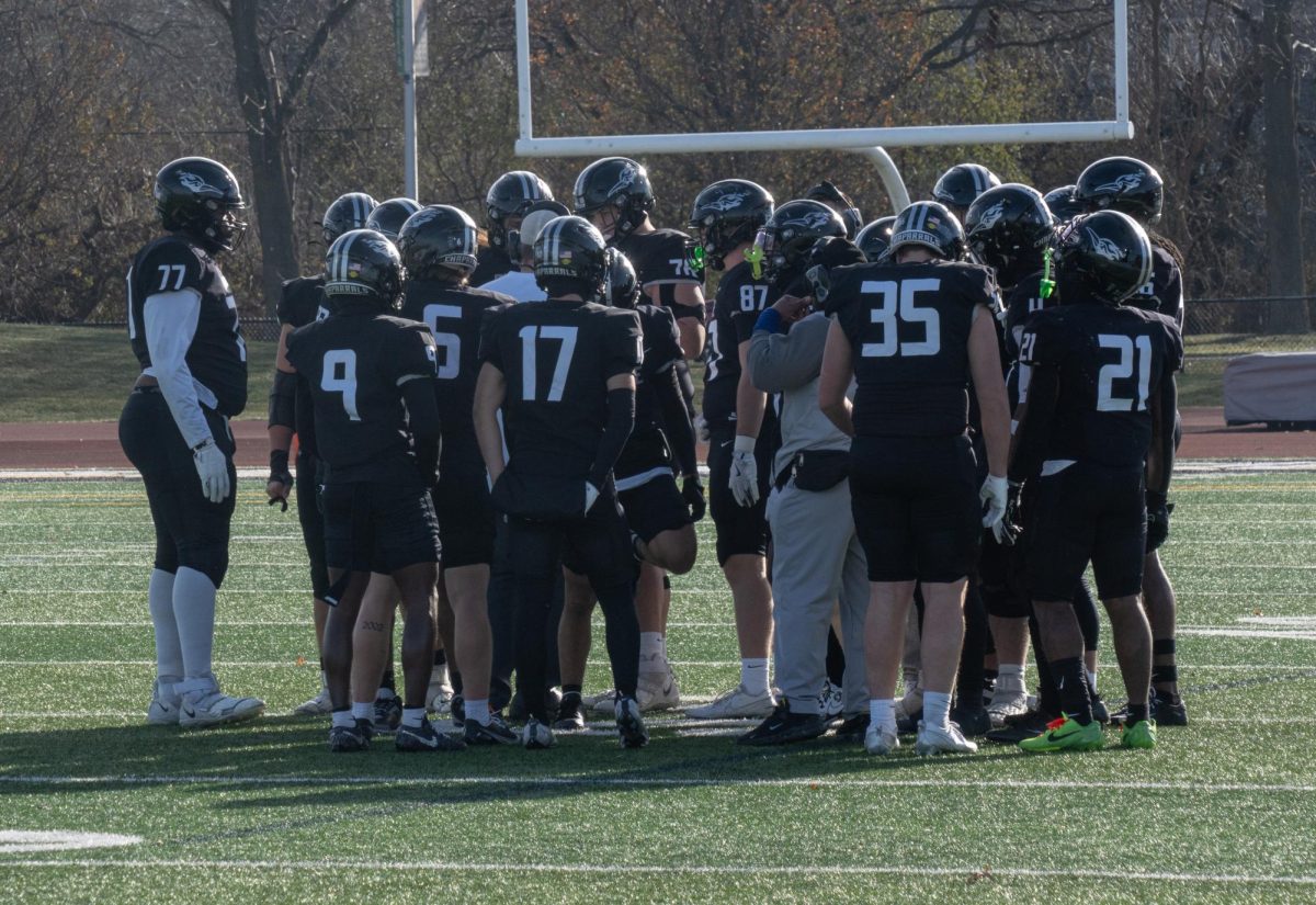 The COD football team huddles before the play. 