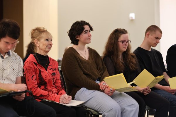 Students listening to speakers during Alpha Mu Gamma induction ceremony.
