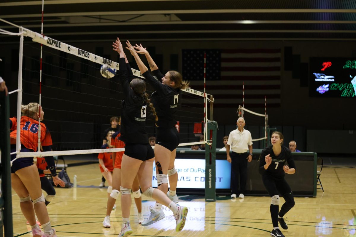 Claire Rambasek and Megan Daca block the ball. 