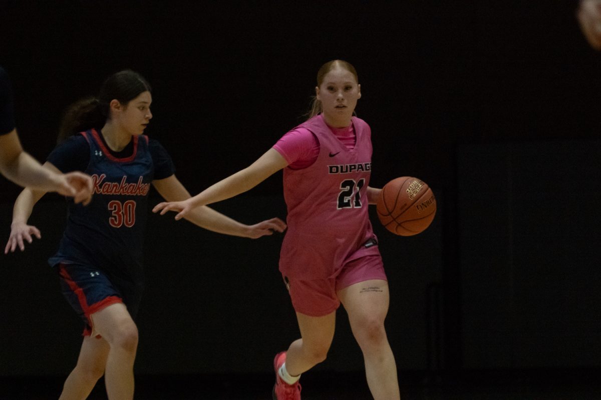 Number 21, Jamie Hasemann running with the ball while a defender tries to come in to steal.
