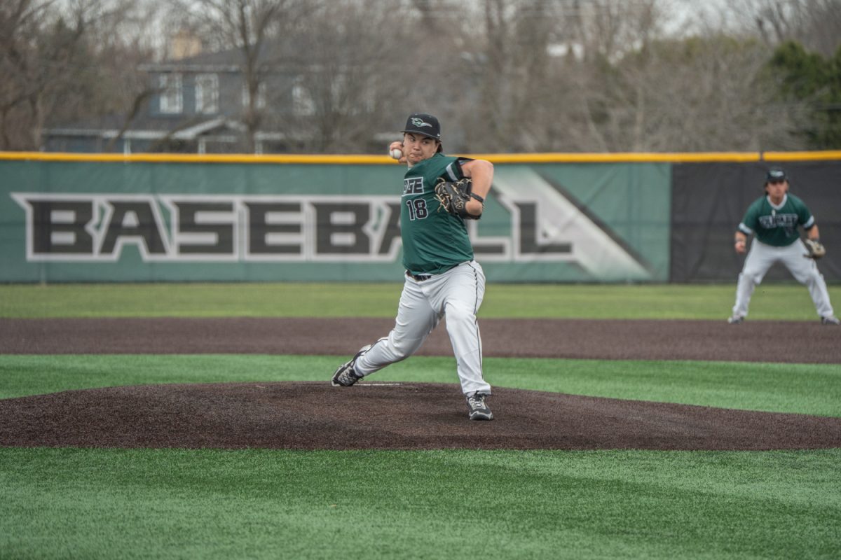 Number 18, Carter Laubinger in the motion of throwing a pitch.
